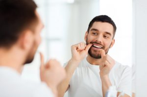 'man flossing in mirror'